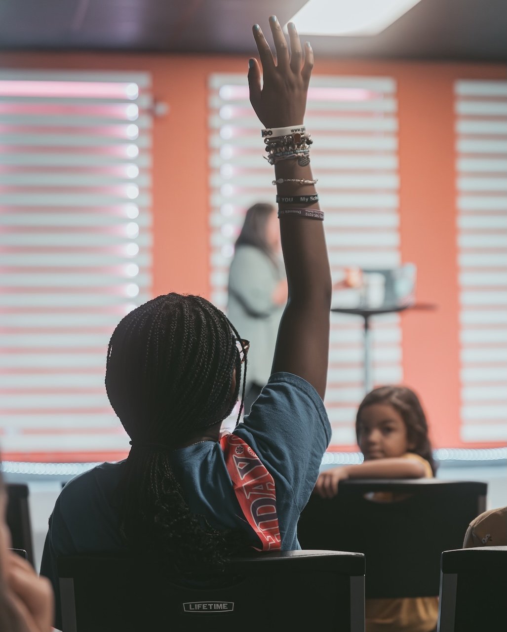 A child raising their hand in class at Stone Edge Kids