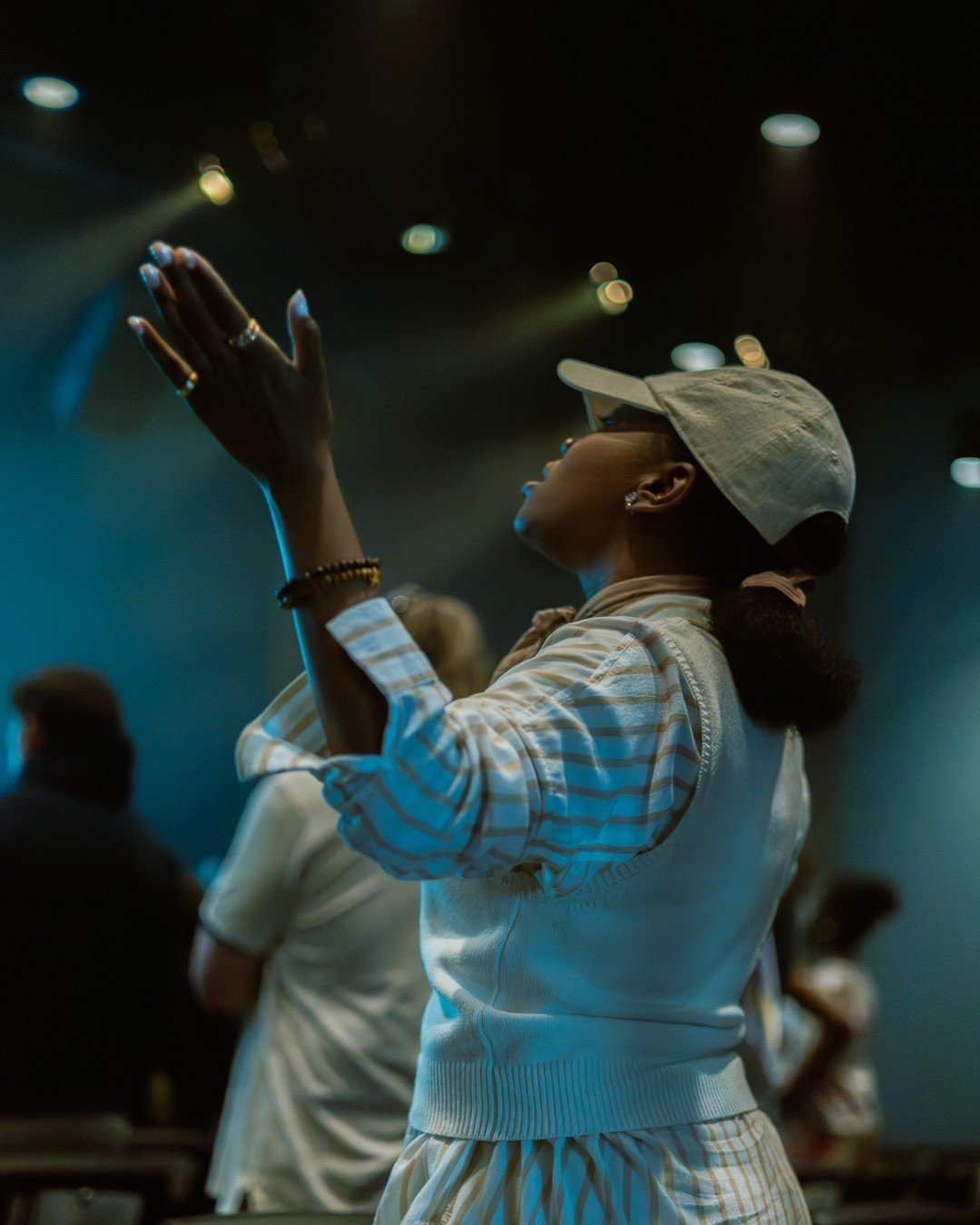 A woman worshipping with hands raised at Stone Edge Church